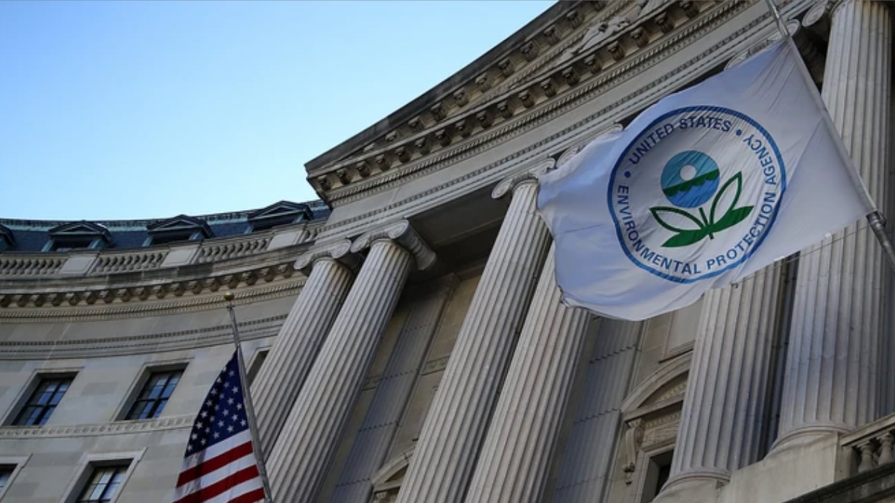 The EPA's flag flies outside of a columned white building.