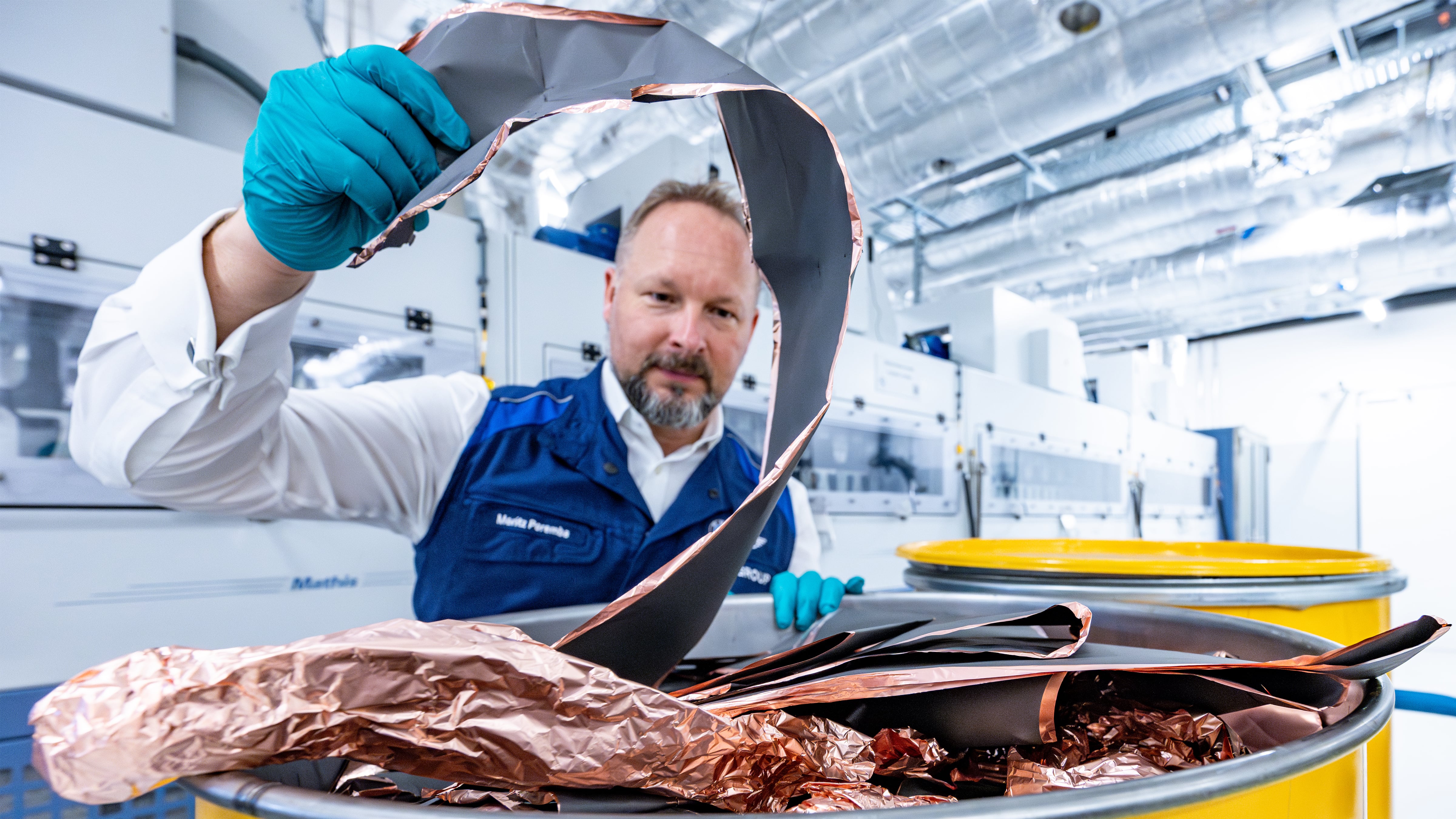 BMW worker holds battery raw materials taken from old batteries that will be reused in new batteries